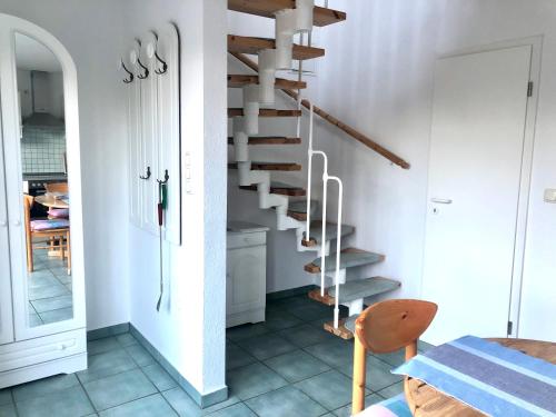 - un escalier dans une chambre blanche avec une table dans l'établissement Strandbummelhaus, à Warnemünde