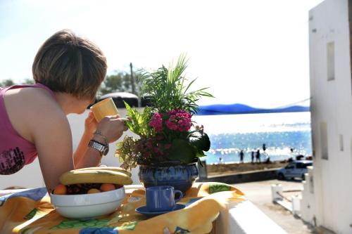 Una donna seduta a un tavolo con un piatto di cibo di Ilion Hotel a Naxos Chora