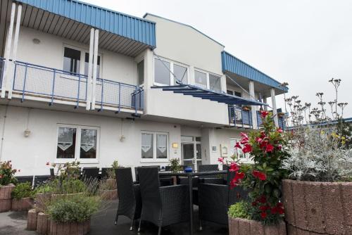 un edificio con sillas y flores delante de él en Good Morning Erfurt, en Erfurt