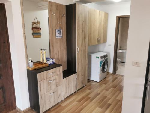 een badkamer met houten kasten en een wasmachine en droger bij Apartament Ovidiu in Giroc