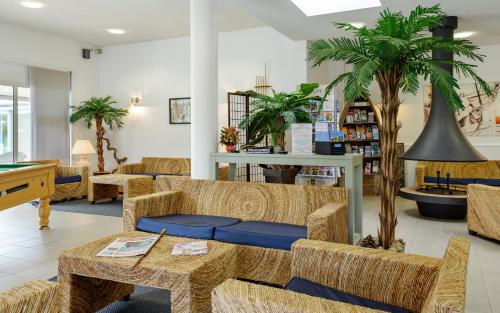 a store with couches and a table and a palm tree at Lagrange Vacances Le Hameau De Peemor Pen in Crozon