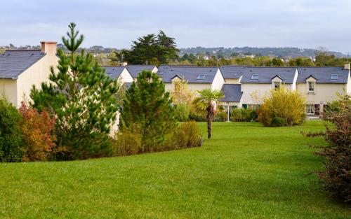 a row of houses with trees in a yard at Lagrange Vacances Le Hameau De Peemor Pen in Crozon