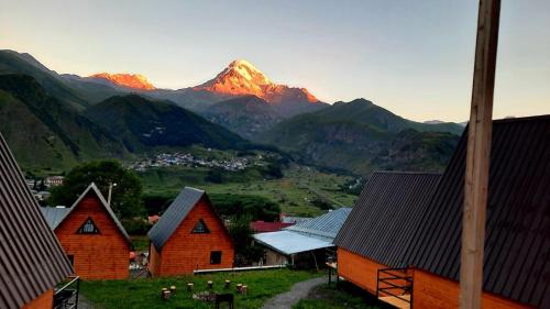 - une vue sur une chaîne de montagnes avec des maisons et des montagnes dans l'établissement Guesthouse Elli & Cottages, à Kazbegi