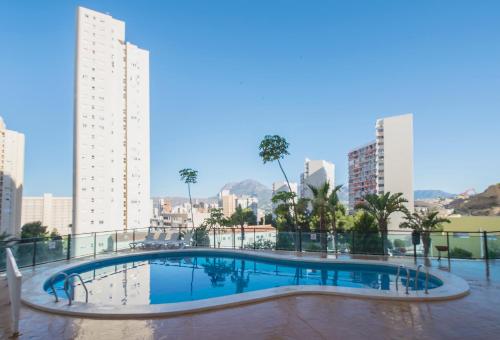 Pierre & Vacances Apartamentos Benidorm Horizon في بنيدورم: مسبح على سطح مبنى فيه مباني