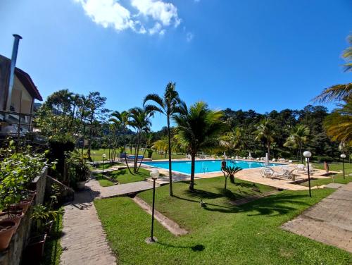 Apartamento até 10 pessoas na enseada Guarujá em condomínio clube praia piscinas salão jogos quadra futebol campo parquinho brinquedos Wi-fi Home office في غوارويا: مسبح في منتجع فيه نخل