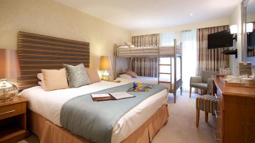 a hotel room with a bed and a desk with a desk at Marwell Hotel - A Bespoke Hotel in Winchester