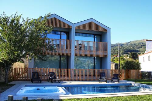 une maison avec une piscine en face d'un bâtiment dans l'établissement Casa João Eusébio 2, à Ponte de Lima