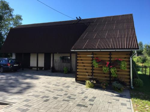 un edificio de madera con flores y plantas. en Lotes apartamenti, en Kuldīga