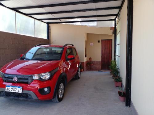 een kleine rode auto geparkeerd in een garage bij La casita de abu! in Salta