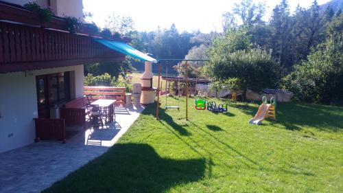 einen Garten mit einem Spielplatz mit einem Tisch und Stühlen in der Unterkunft Apartma Lara in Bled