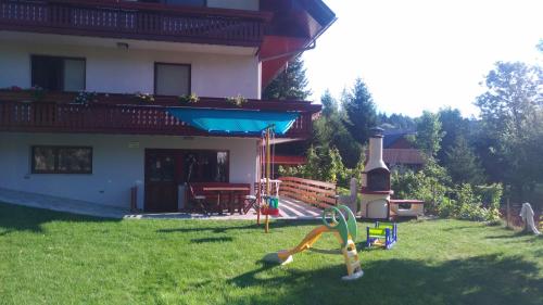 ein Haus mit Spielplatz im Hof in der Unterkunft Apartma Lara in Bled