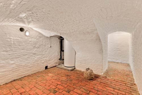 a cat sitting on a brick floor in a white room at Huis Potaerde, luxe villa, vakantiewoning - landhuis nabij Brussel in Merchtem