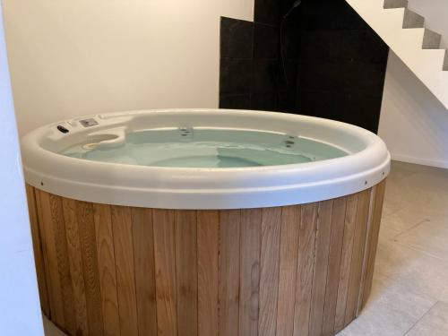 een hot tub in een kamer met een houten bad bij CaCeLe Raveelzicht in Zulte