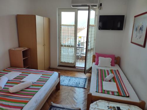 Habitación pequeña con 2 camas y balcón. en Smestaj Vella, en Herceg-Novi