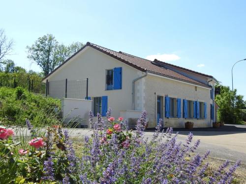 une maison avec des fenêtres à volets bleus et des fleurs dans l'établissement Gîte indépendant avec SPA, jardin, terrain de pétanque, proche vignoble du Champagne à Colombey - FR-1-611-45, à Colombey-les-Deux-Églises