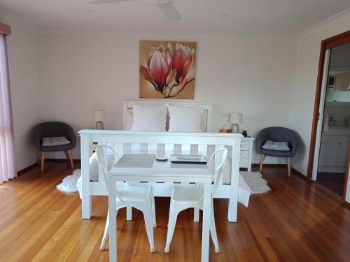 une table à manger blanche avec des chaises blanches et un tableau dans l'établissement Kincumber House, à Kincumber