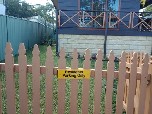 un panneau sur une clôture devant une maison dans l'établissement Kincumber House, à Kincumber