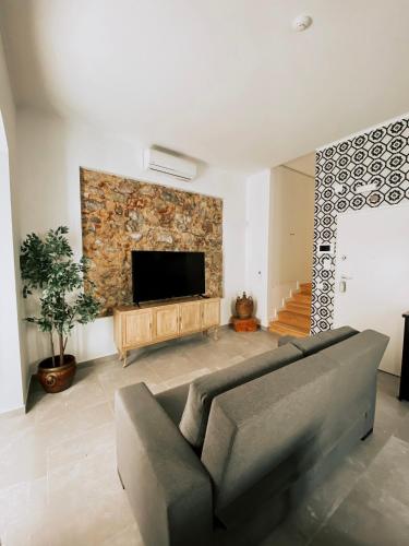 a living room with a couch and a flat screen tv at Baixa-Mar Setúbal Miradouro in Setúbal