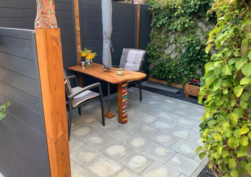 una mesa de madera y sillas en un patio en FeWo "Zwischen den Meeren", en Rendsburg