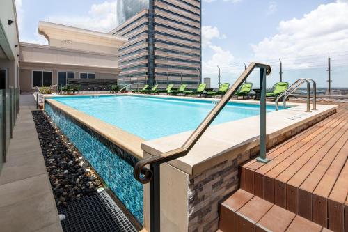 een zwembad met stoelen en een gebouw bij Blossom Hotel Houston in Houston