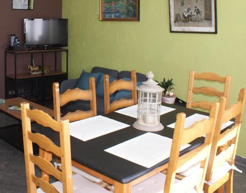 een eettafel en stoelen met een zwart-witte tafel bij Café du Pêcheurs in Bouillon