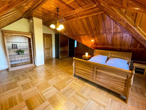 - une grande chambre avec un lit et un plafond en bois dans l'établissement Dom na Poniatowie, à Wałbrzych