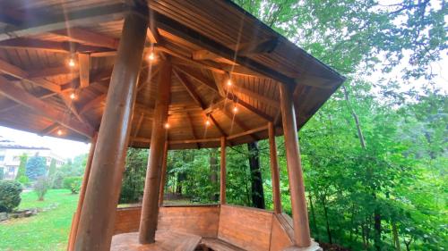 a wooden gazebo in a park with trees at Гранд Алексік in Truskavets