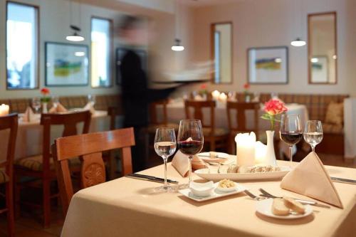 a table in a restaurant with glasses of wine at Hotel Akazienhaus in Herzogenaurach