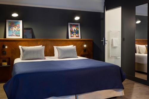 - une chambre dotée d'un grand lit avec des draps bleus dans l'établissement RockyPop Grenoble Hotel, à Grenoble