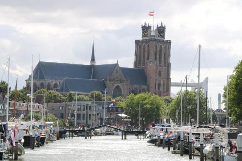 een groot gebouw met een klokkentoren en een gebouw met boten bij B&B verDRAAId fijn in Dordrecht