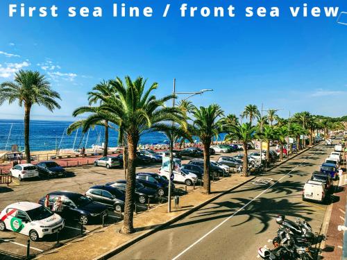 eine Straße mit Autos auf einem Parkplatz neben dem Strand in der Unterkunft Happy LLoret in Lloret de Mar