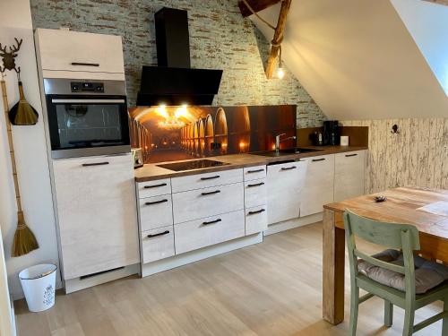 una cucina con armadi bianchi e tavolo in legno di Gästehaus Rheinromantik a Bacharach