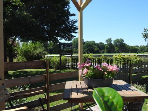 una mesa de picnic de madera con una maceta de flores. en Bed & Breakfast Boszicht Leeuwarden, en Leeuwarden