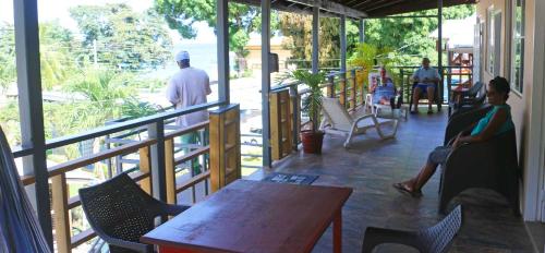 una habitación con personas sentadas sobre sillas y una mesa en La Casa de Castara, en Castara