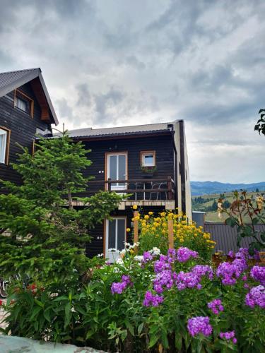 une maison avec des fleurs devant elle dans l'établissement Apartments center Zorić, à Žabljak