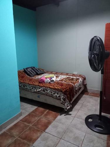 een slaapkamer met een bed in een kamer met een ventilator bij La casita de abu! in Salta