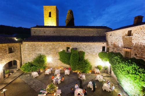 un groupe de personnes assises à des tables devant un bâtiment dans l'établissement Castello di Spaltenna Exclusive Resort & Spa, à Gaiole in Chianti