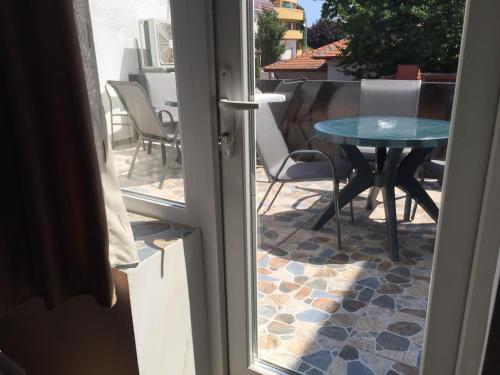 eine offene Tür zu einer Terrasse mit einem Tisch und Stühlen in der Unterkunft Villa 3 papuci in Constanţa