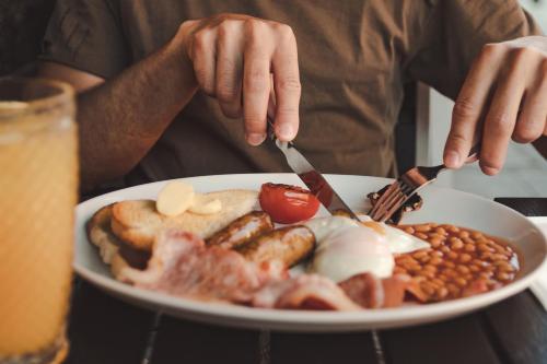 una persona sta mangiando un piatto di cibo per la colazione di Hotel Colessio a Stirling