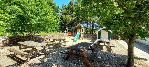 un parco con tavoli da picnic e un parco giochi di Lustrup Farmhouse a Ribe