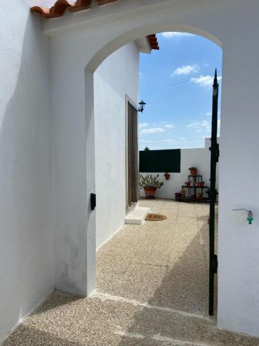 een boog in een wit gebouw met een raam bij Casa do Canto - Uma casa no campo, perto da praia. in Óbidos