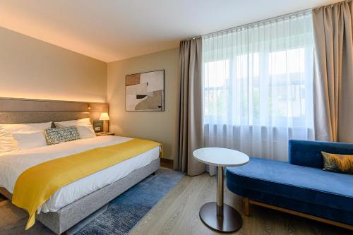 Habitación de hotel con cama y sofá azul en Hotel Europa, en Múnich