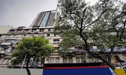 un grand bâtiment avec des arbres devant lui dans l'établissement Itsy Hotels Heraa International, à Mumbai