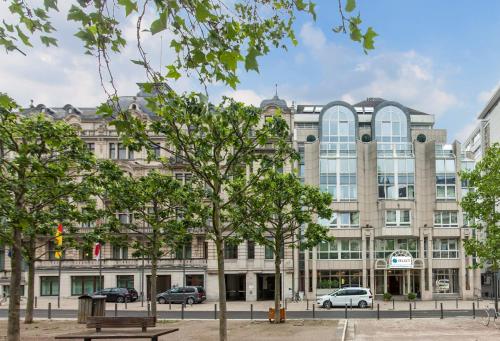 un grand bâtiment avec des arbres devant lui dans l'établissement Select Hotel Wiesbaden City, à Wiesbaden