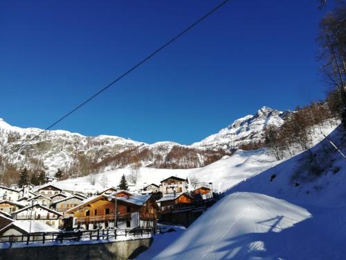 een met sneeuw bedekt dorp met huizen en een berg bij Chalet Gaspard in Valtournenche