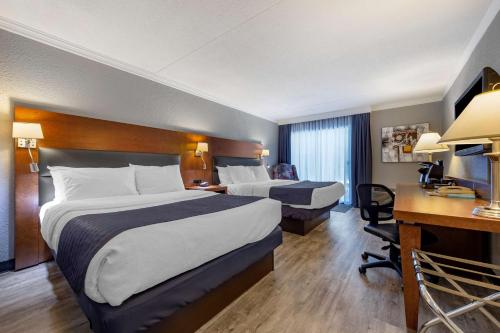 een hotelkamer met 2 bedden en een bureau bij Best Western Hotel Universel Drummondville in Drummondville