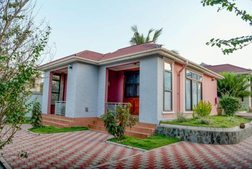 una casa con una porta rossa su un vialetto di mattoni di Samanene Hotel a Mwanza