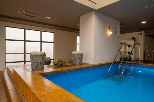 una piscina con una escalera en una habitación en Intercity Caxias do Sul, en Caxias do Sul