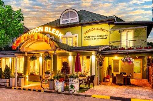 un edificio amarillo con un patio delante de él en Penzion Blesk, en Ružomberok