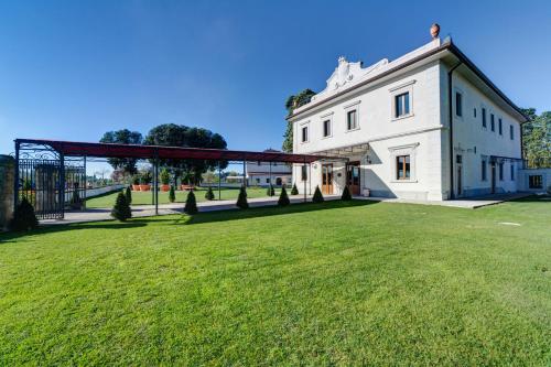 een groot grasveld naast een wit gebouw bij Villa Tolomei Hotel & Resort in Florence